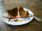 Cooked Guatemalan Green Ayote wedges on a plate with a spoon, flesh gone deep amber