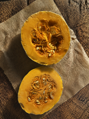 Doran Round squash cut in half showing golden orange flesh and seed cavity - dense sweet moschata pie squash