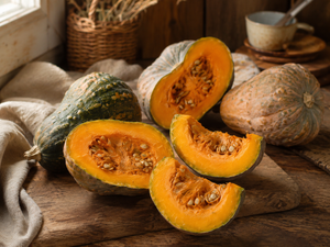 Halved Jamaican Tropical calabaza showing orange flesh on a farmhouse table - heat tolerant moschata heirloom