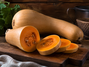 Tahitian Melon squash cut open showing deep orange flesh, heirloom Cucurbita moschata